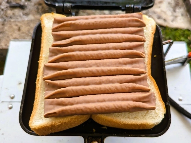 ホットサンドメーカーの上に食パンをのせて更にルマンドをのせた