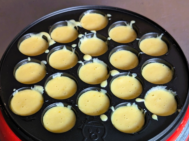 タコ焼き器にベビーカステラの生地を入れる