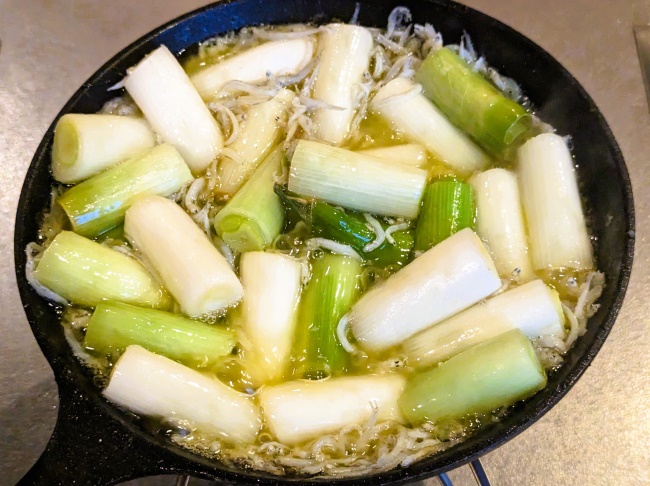 長ネギとしらすのアヒージョに調味料を入れて煮詰める