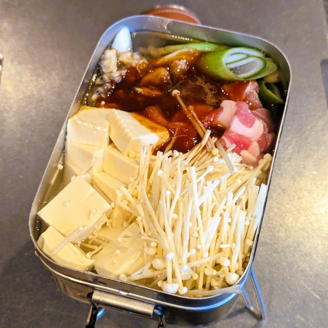 メスティンにスンドゥブチゲの具材と調味料を入れる