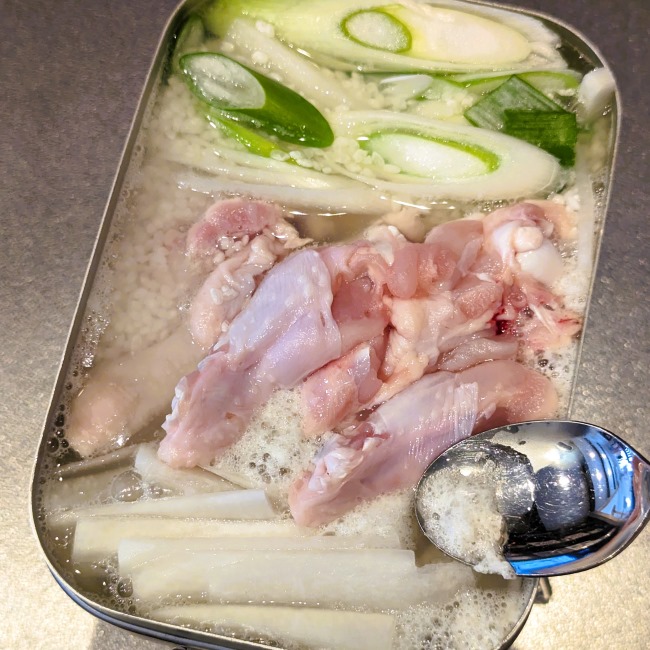 参鶏湯から出た灰汁を取る