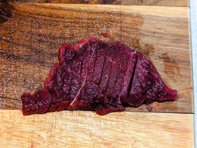 鹿肉に食べやすいように隠し包丁を入れる