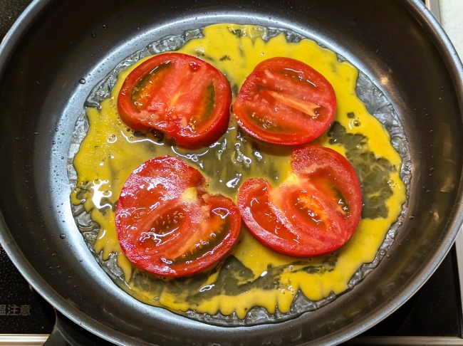 ライスペーパーの上に溶き卵とスライストマトをのせる