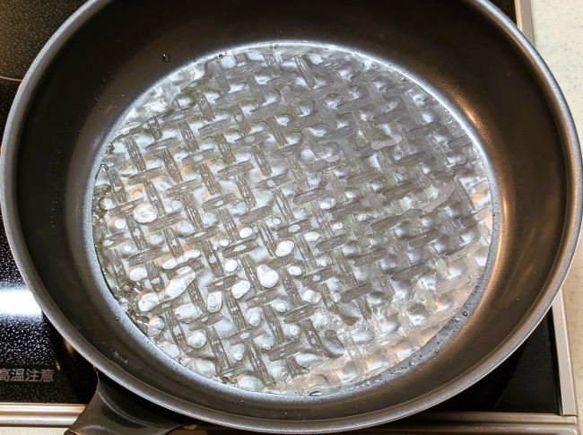 オリーブオイルと水の敷いたフライパンにライスペーパーをのせる