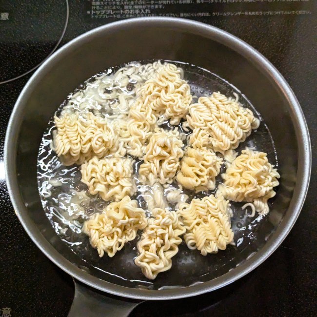 フライパンで小さくした麺を茹でる