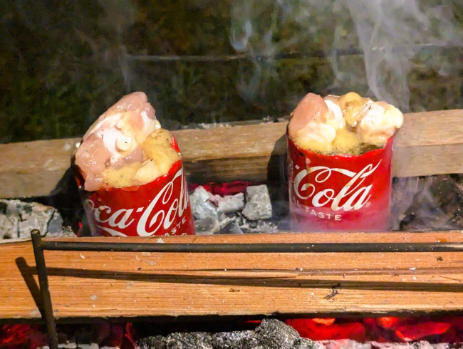 焚火にコーラ缶の手羽元のコーラ煮を置く