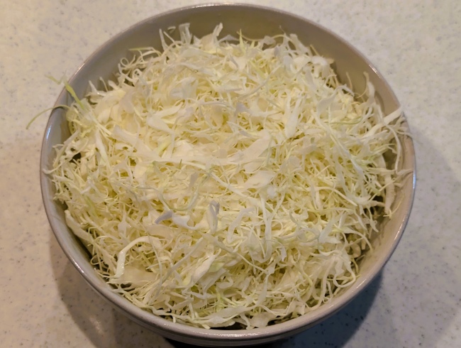 ヤンニョム豚丼ののごはんとキャベツを盛る