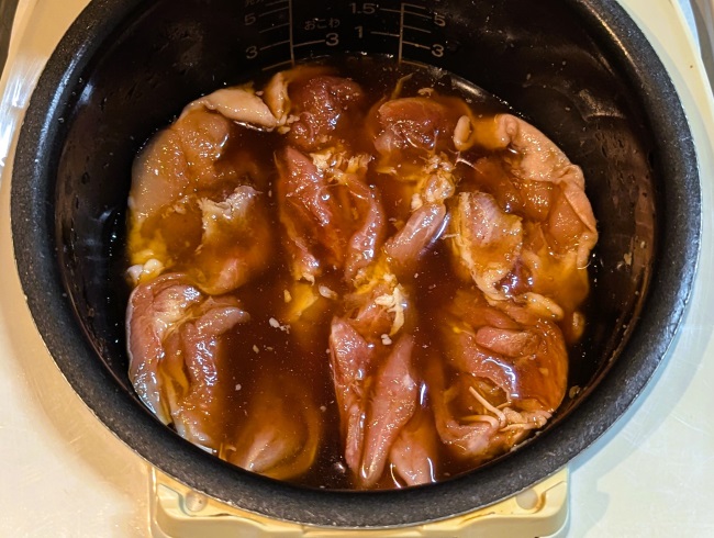 炊飯器に鶏肉と照り焼きのソースが入っている