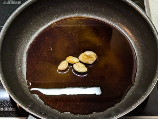 フライパンに入れたにんにくと調味料