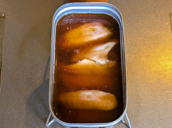 調味料を加えた手羽中をビールで煮込む