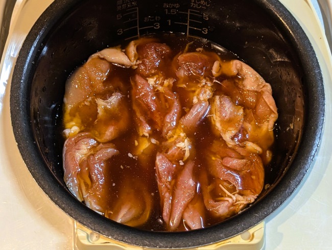 鶏もも肉をタレに加えてしっかり揉み込み、味を染み込ませている。