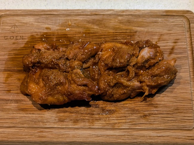 炊飯器で調理したハニーチキンをまな板の上でカットしている。肉汁があふれ出す。